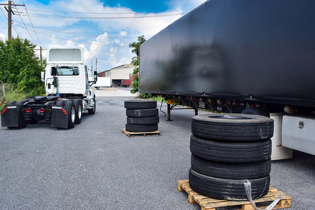 conestoga tarped trailer unloading a delivery of truck tires